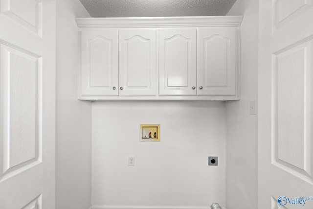 laundry area with electric dryer hookup, cabinet space, a textured ceiling, and hookup for a washing machine