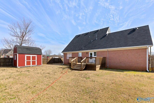 back of property with an outbuilding, a storage shed, a fenced backyard, and brick siding