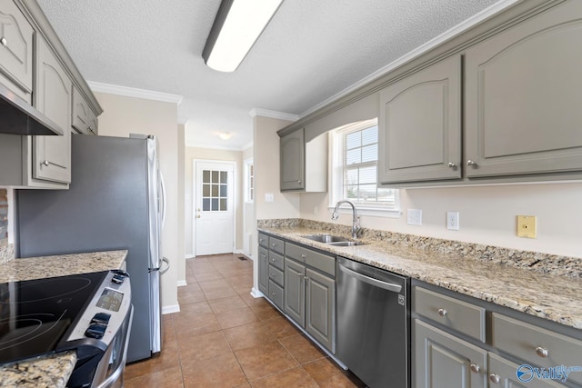 kitchen featuring dark tile patterned flooring, gray cabinets, a sink, ornamental molding, and stainless steel appliances