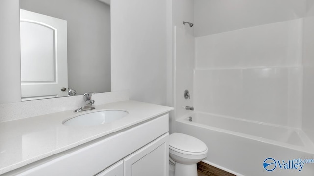 bathroom featuring shower / bathing tub combination, wood finished floors, toilet, and vanity
