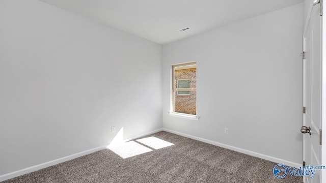 carpeted empty room featuring baseboards and visible vents