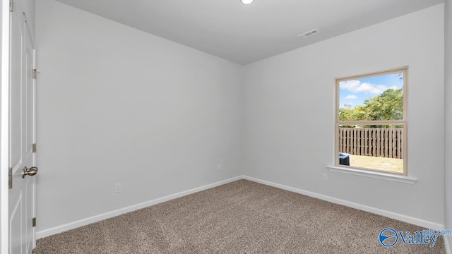 spare room featuring visible vents, carpet flooring, and baseboards