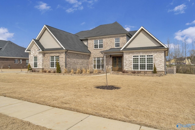 view of front facade with brick siding and a shingled roof