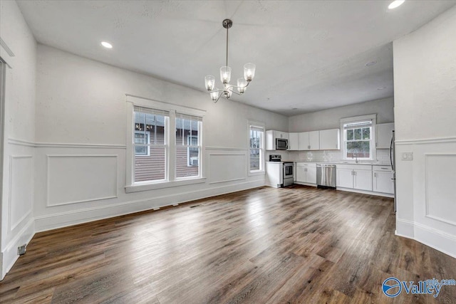 unfurnished living room with dark hardwood / wood-style flooring, a chandelier, and sink