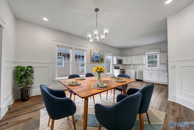 dining space featuring sink, a notable chandelier, and dark hardwood / wood-style floors