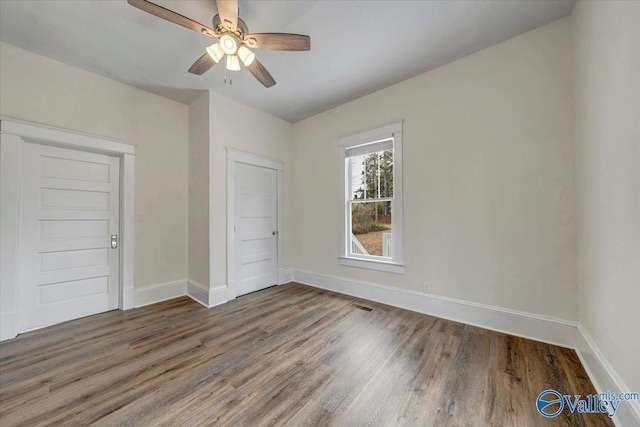 unfurnished bedroom with dark hardwood / wood-style floors and ceiling fan