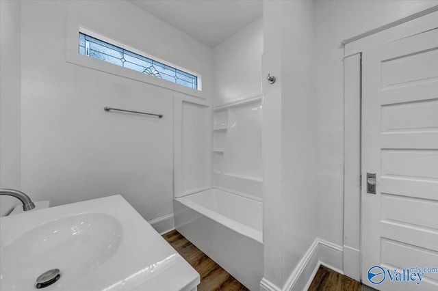 bathroom featuring sink, hardwood / wood-style flooring, and tub / shower combination