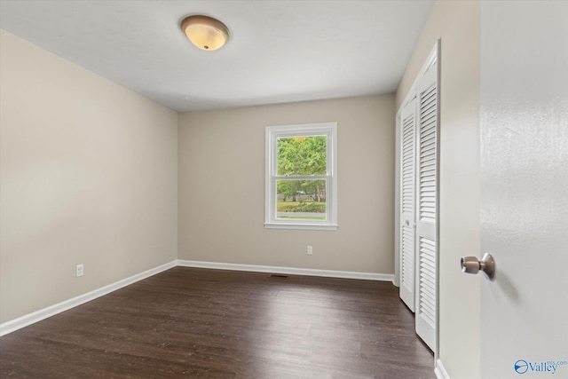 605 Holland Dr SW, Decatur, AL 35601 - unfurnished bedroom featuring a closet, baseboards, and dark wood finished floors