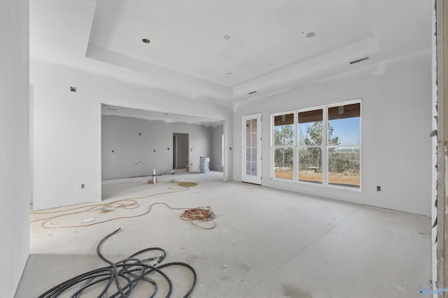 unfurnished living room with a raised ceiling and visible vents