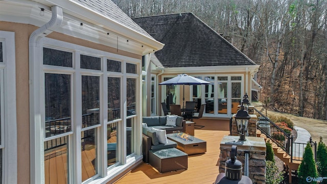 wooden deck with french doors, an outdoor fire pit, and a sunroom