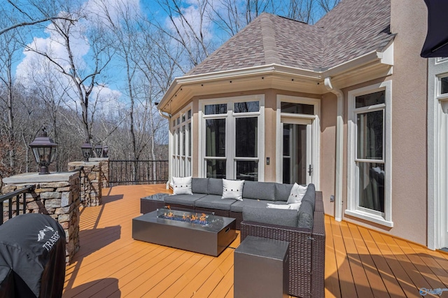 deck with an outdoor living space with a fire pit