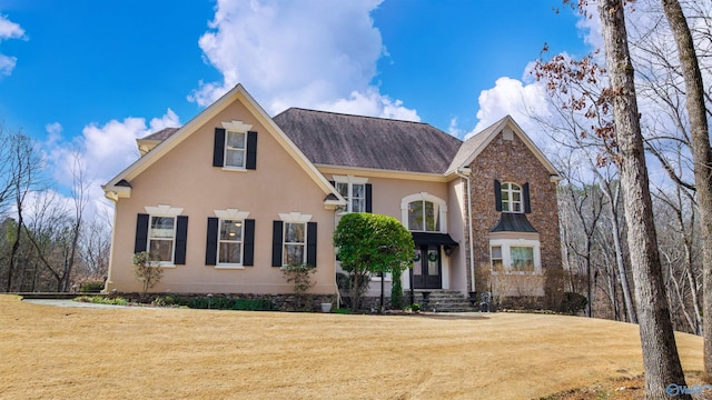 traditional-style home featuring a front yard and stucco siding