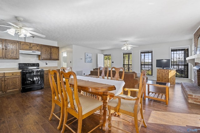 220 County Road 564, Leesburg, AL 35983 - dining room with dark wood-type flooring, a brick fireplace, ceiling fan, and visible vents