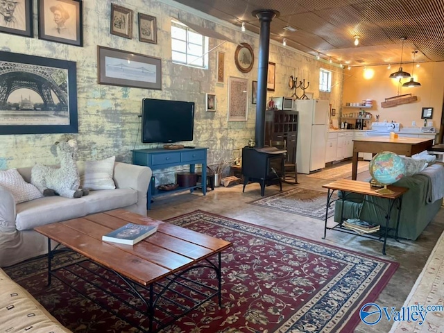 living room featuring a wood stove and concrete floors