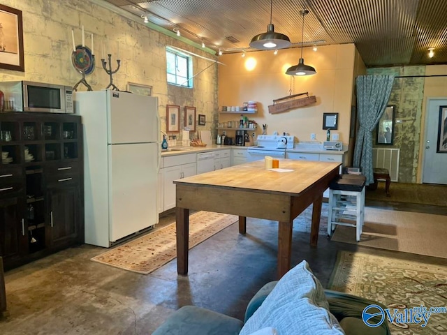 kitchen with white cabinets, white appliances, and hanging light fixtures