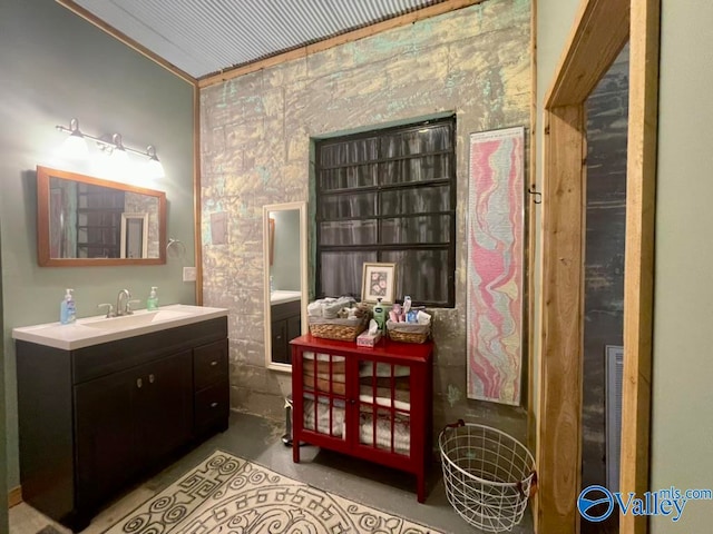 bathroom featuring vanity, concrete floors, and ornamental molding