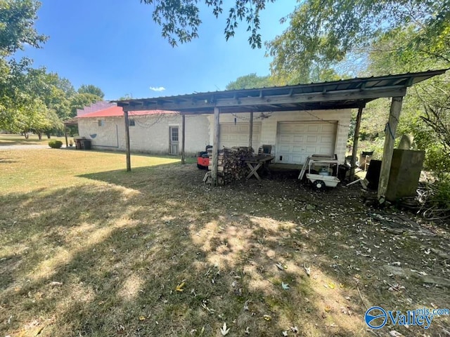 exterior space featuring a yard, a garage, and an outbuilding