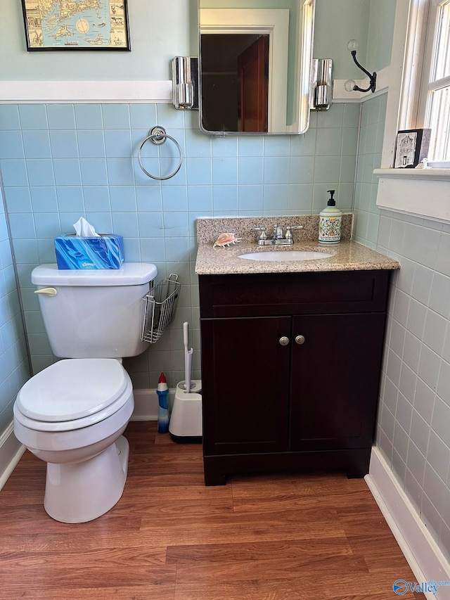 bathroom featuring vanity, toilet, tile walls, and wood-type flooring