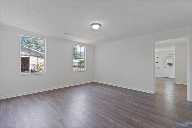 empty room with a textured ceiling, ornamental molding, and dark hardwood / wood-style flooring