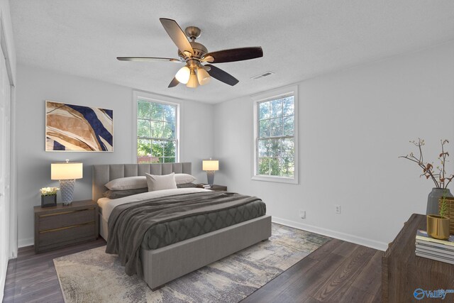 unfurnished room featuring dark hardwood / wood-style flooring, ceiling fan, and a textured ceiling