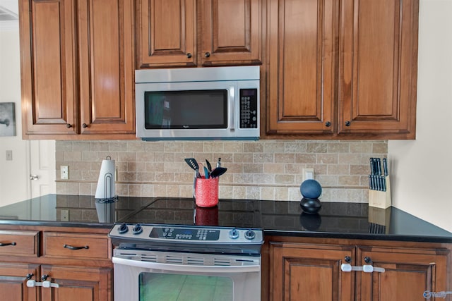 kitchen with appliances with stainless steel finishes, brown cabinets, and backsplash