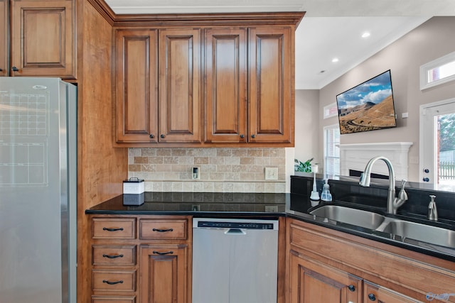 kitchen with dark countertops, brown cabinets, dishwasher, and freestanding refrigerator