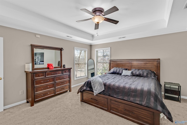 bedroom with light carpet, a raised ceiling, visible vents, and baseboards