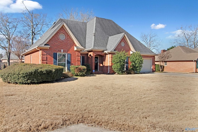 view of front of house with a garage, brick siding, driveway, and a front lawn