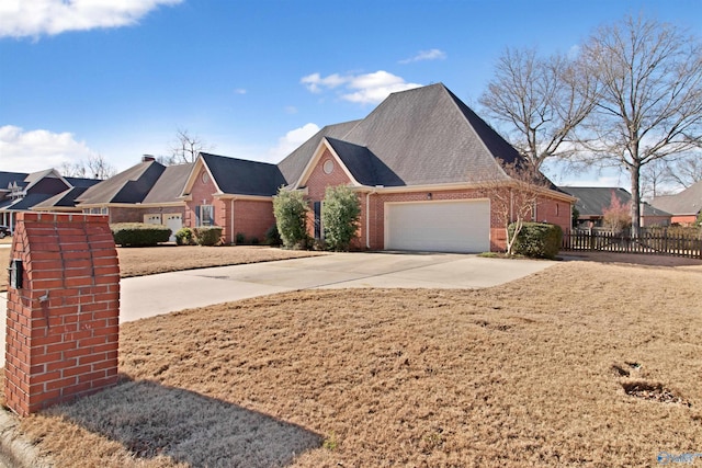 view of front of house with driveway, an attached garage, fence, and brick siding