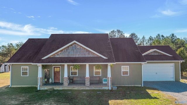 craftsman house featuring a front lawn, a porch, and a garage