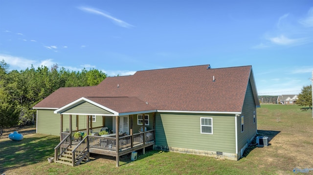 back of property featuring central air condition unit, a wooden deck, and a lawn