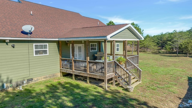 back of property with a lawn and covered porch