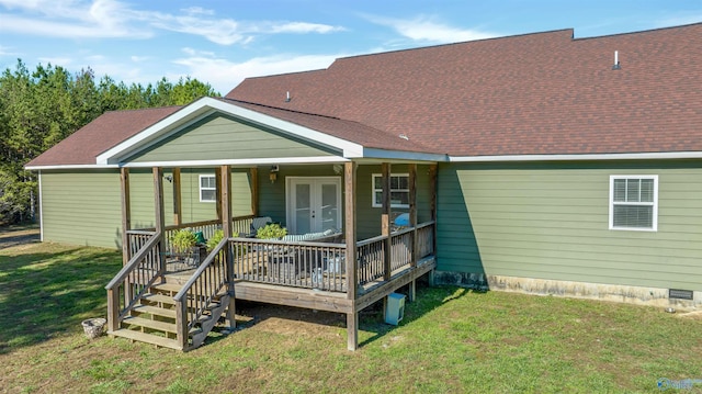 rear view of property with a lawn, a deck, and french doors