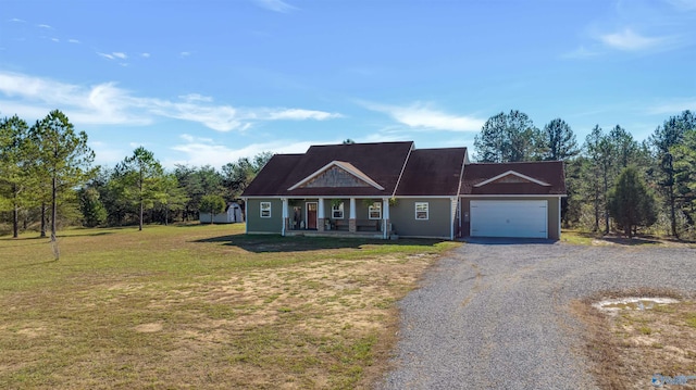 view of front of home featuring covered porch, a garage, and a front lawn