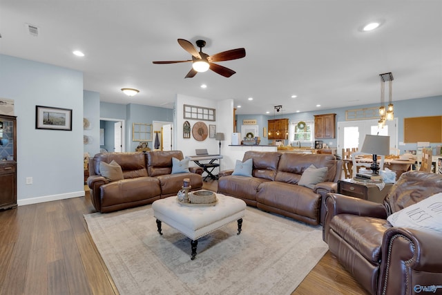 living room with ceiling fan and light wood-type flooring