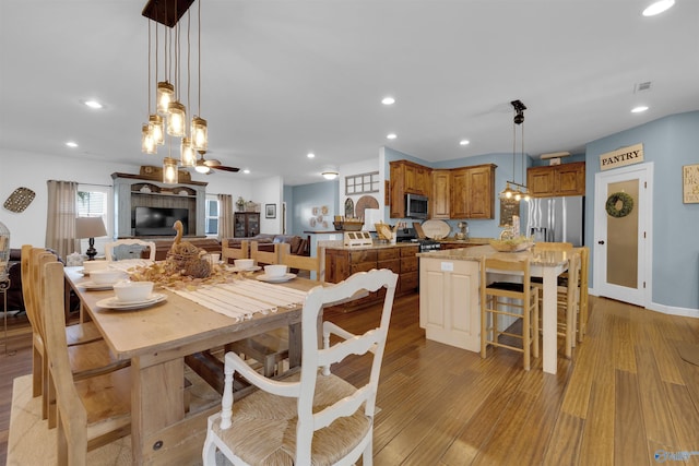 dining space with ceiling fan and light hardwood / wood-style flooring