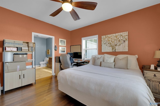 bedroom with hardwood / wood-style floors, ensuite bathroom, and ceiling fan