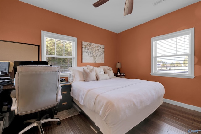 bedroom with ceiling fan, dark hardwood / wood-style flooring, and multiple windows