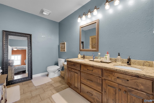 bathroom featuring toilet, vanity, tile patterned floors, and ceiling fan