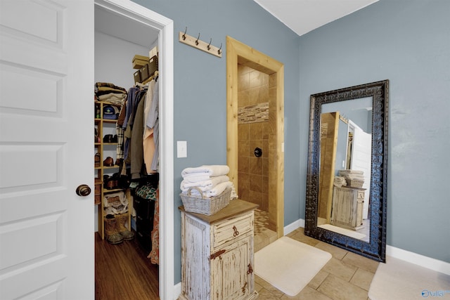 bathroom with a tile shower and hardwood / wood-style flooring