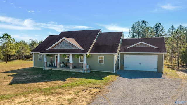 view of front facade featuring covered porch, a garage, and a front yard