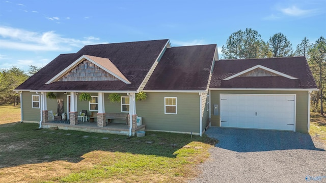 view of front of property with a front yard, a porch, and a garage