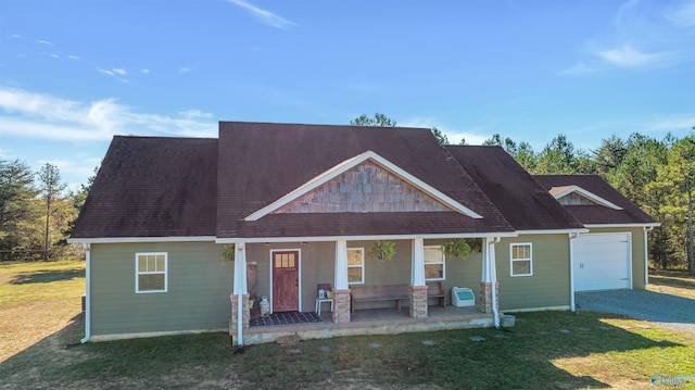 craftsman house featuring a garage, covered porch, and a front lawn