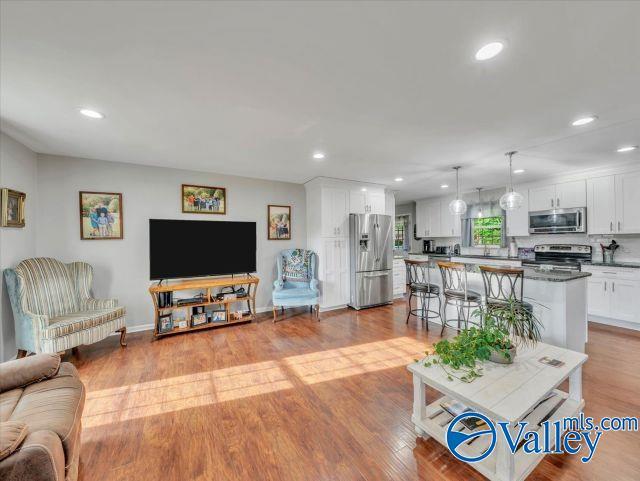 living area with recessed lighting and wood finished floors