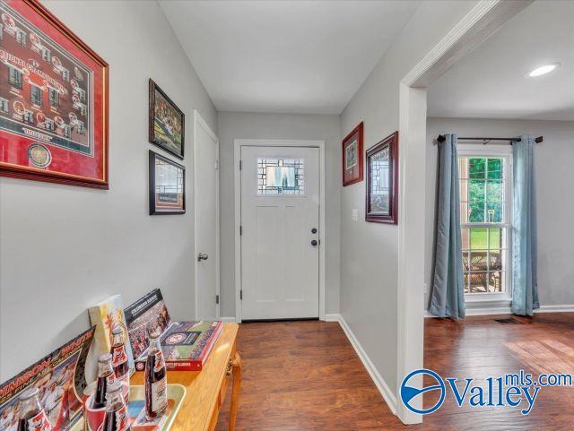 doorway featuring baseboards and wood finished floors