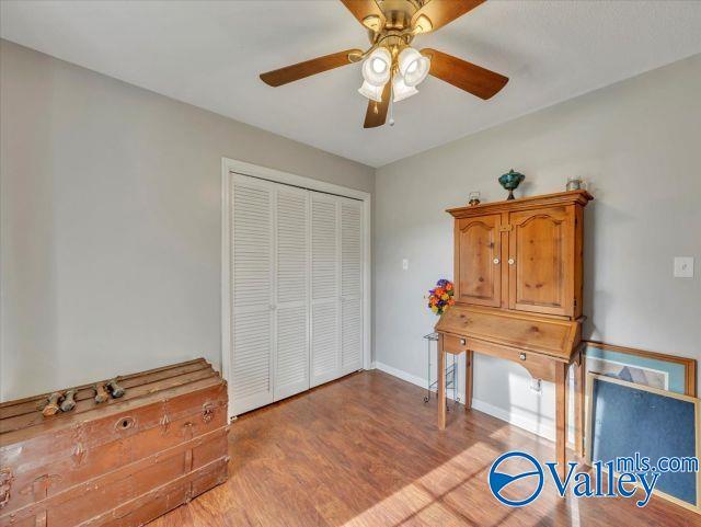 interior space featuring baseboards, ceiling fan, a closet, and wood finished floors