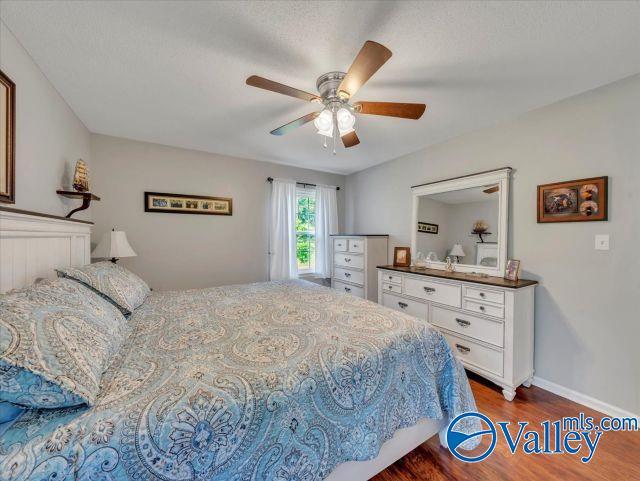 bedroom featuring baseboards, dark wood finished floors, and ceiling fan
