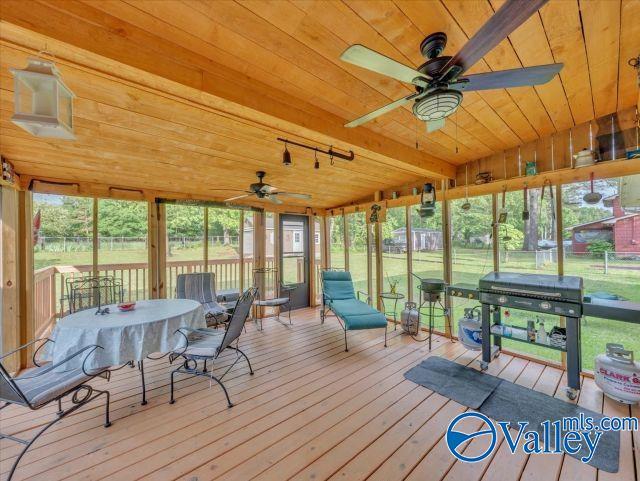 sunroom featuring a ceiling fan and outdoor dining area