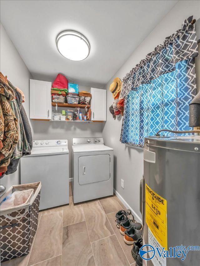 laundry room with baseboards, washer and clothes dryer, cabinet space, and electric water heater