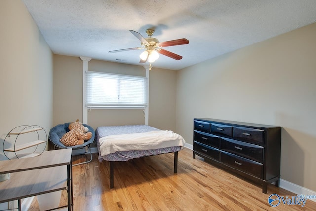 14850 Creek Ln, Athens, AL 35613 - bedroom with light wood-type flooring, a textured ceiling, ceiling fan, and baseboards